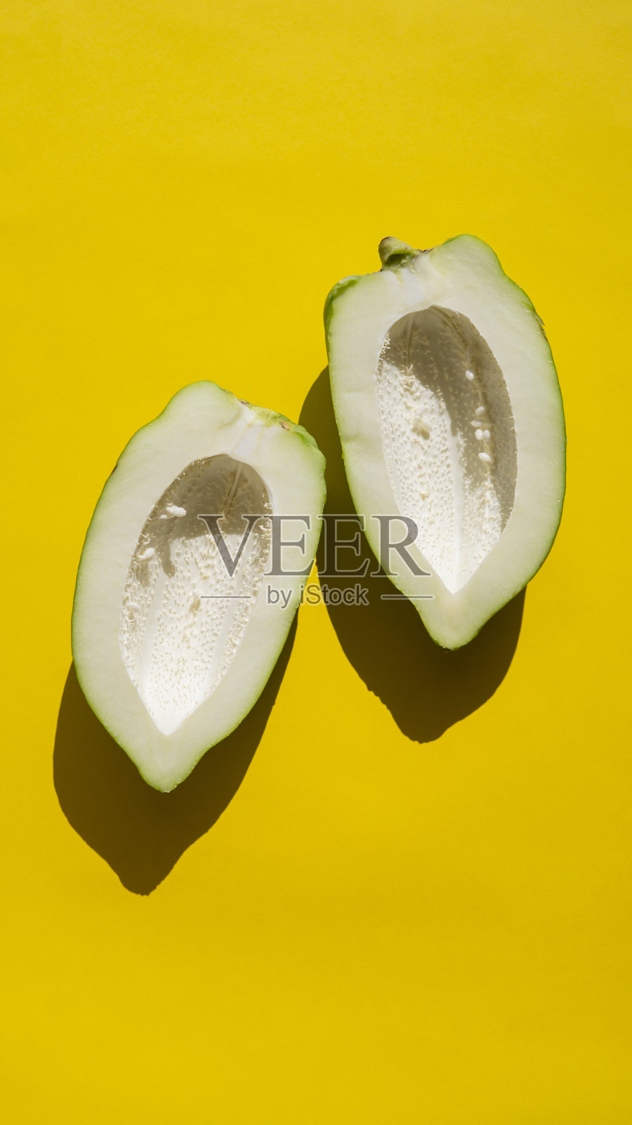 极简的绿色木瓜在黄色的背景照片摄影图片