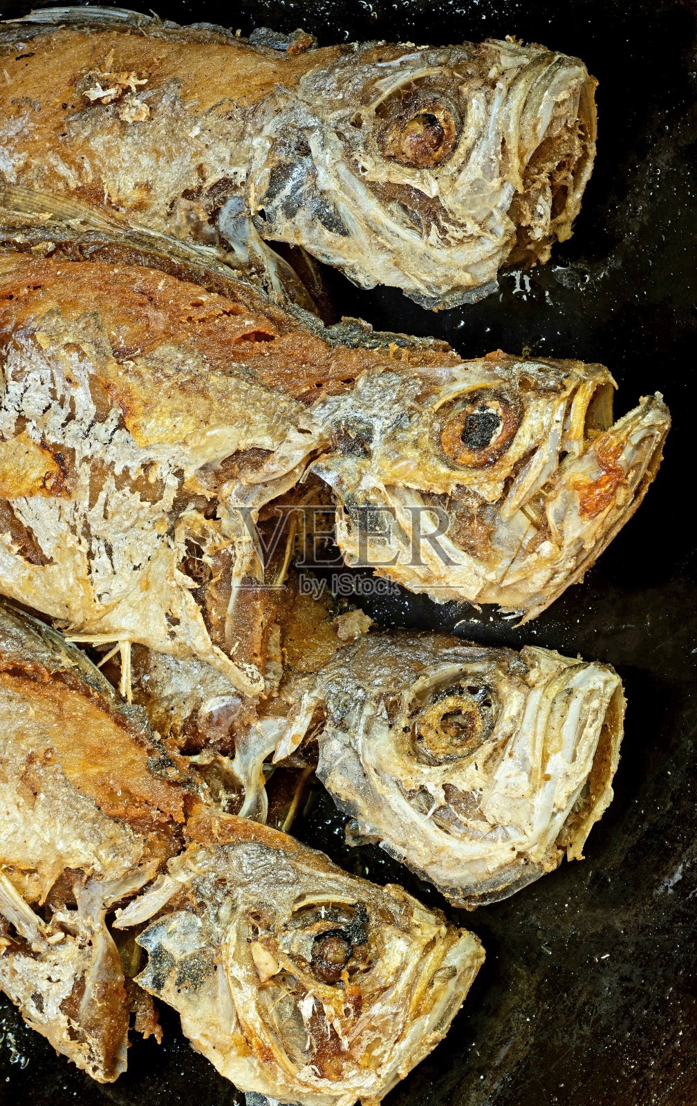 在平底锅中煎炸白鱼-食物准备。照片摄影图片