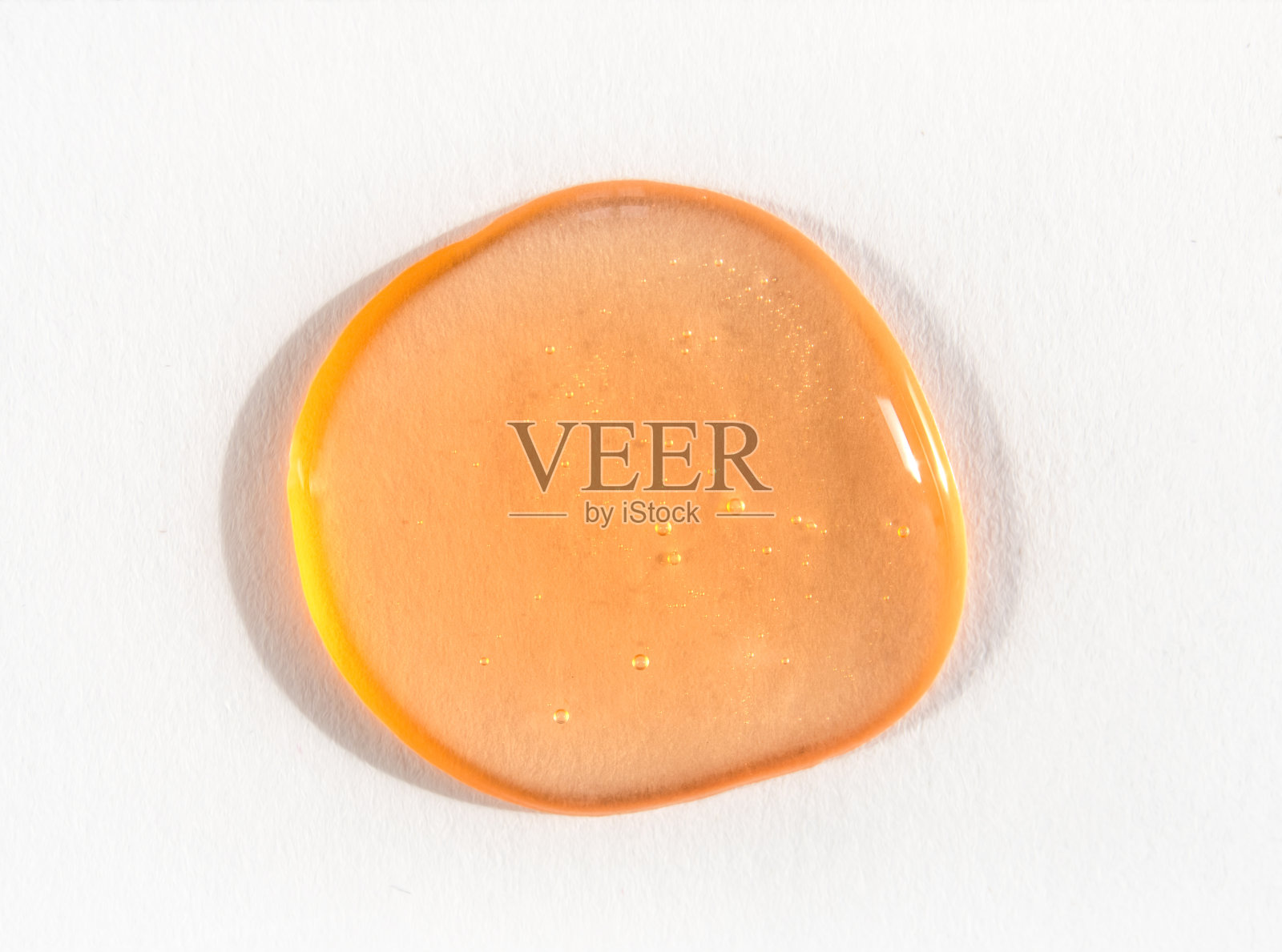 橙色化妆品凝胶或黏液滴在白色背景上照片摄影图片