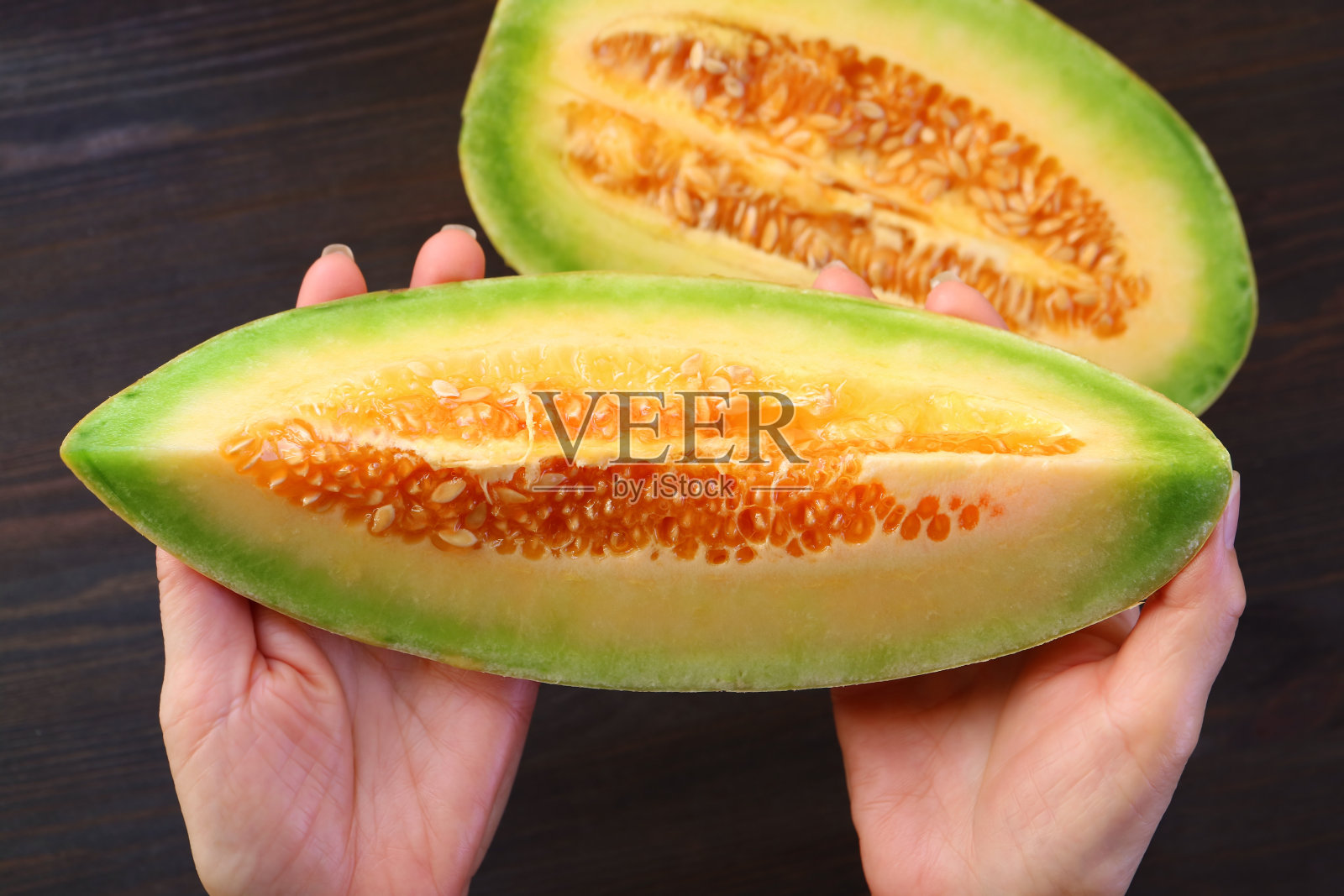 特写一片新鲜成熟的泰国甜瓜在女人的手中照片摄影图片