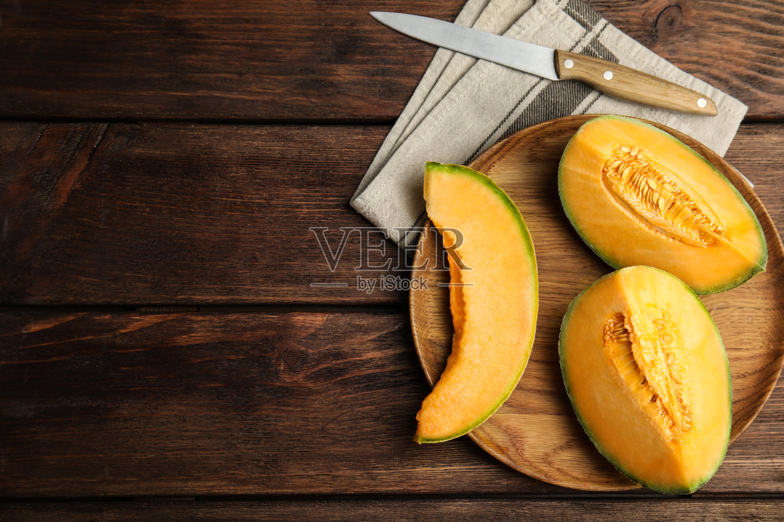 香醇鲜切的甜瓜，平铺在木桌上。空间的文本照片摄影图片