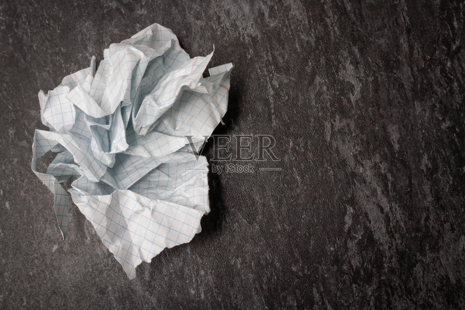 桌子上有皱巴巴的破纸。记事本在皱巴巴的纸背景。照片摄影图片