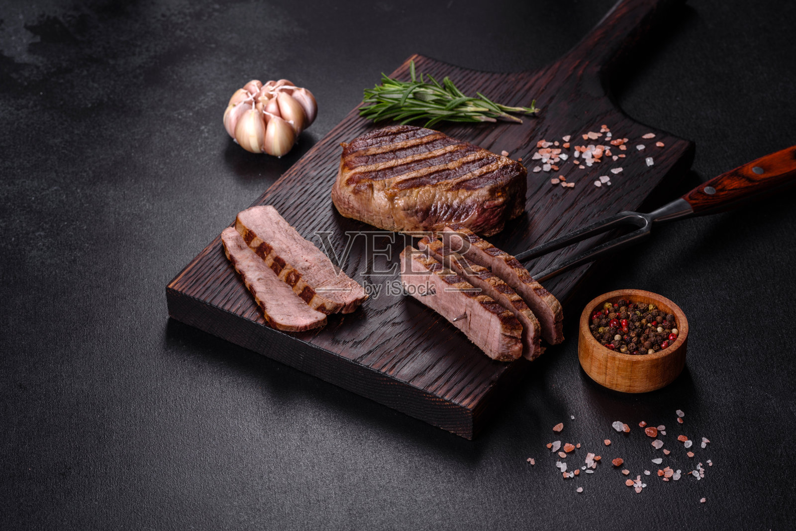 新鲜多汁美味的牛排在黑暗的背景照片摄影图片