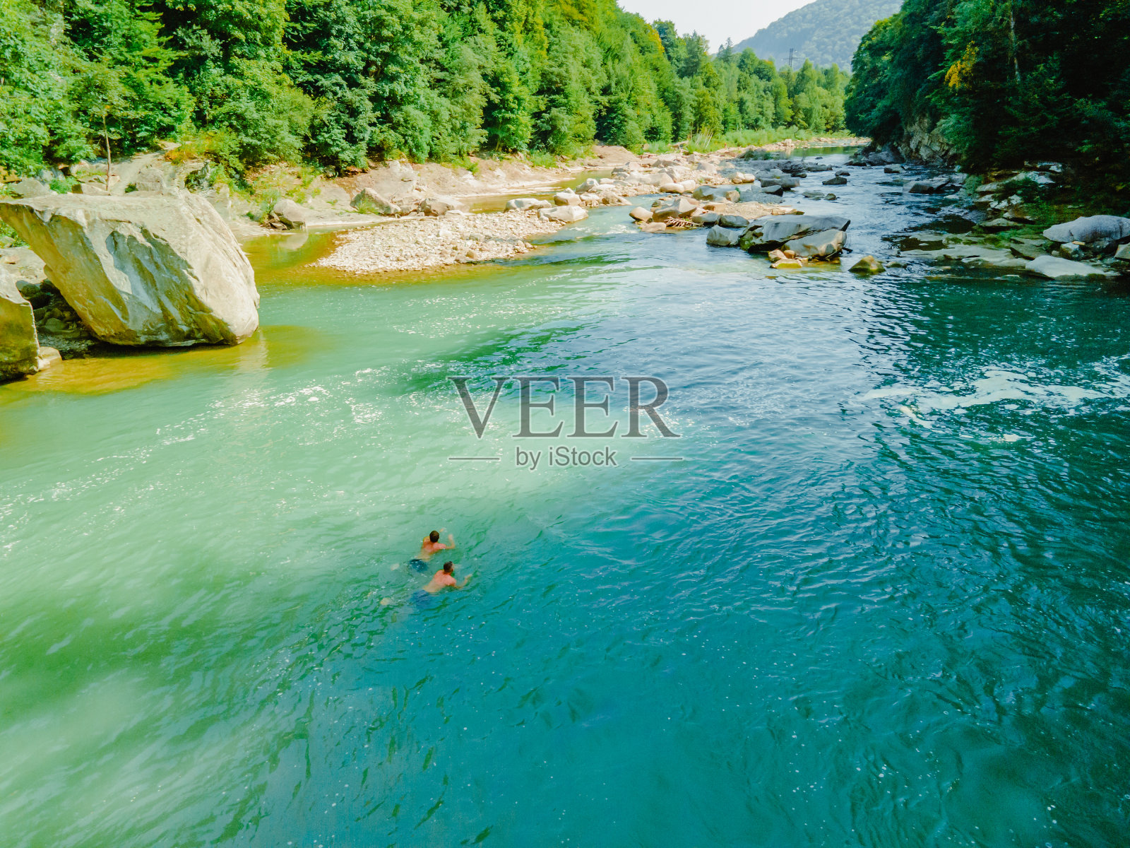 两个人在山里的河里游泳照片摄影图片