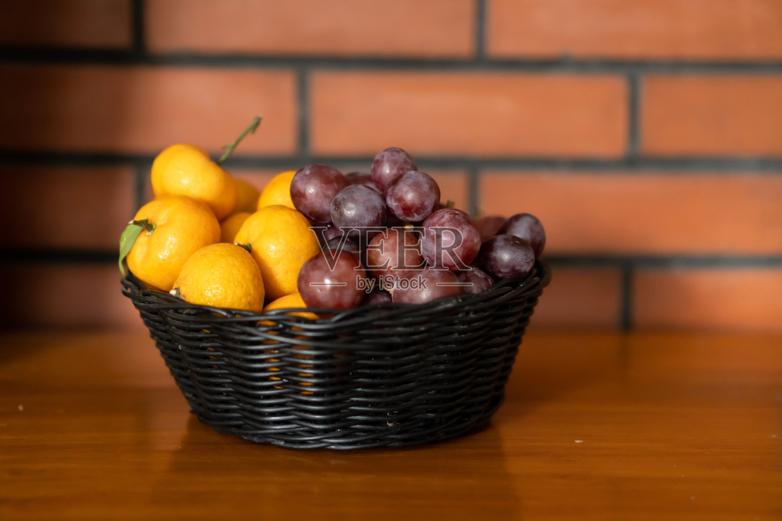 橙子和葡萄放在小篮子里照片摄影图片