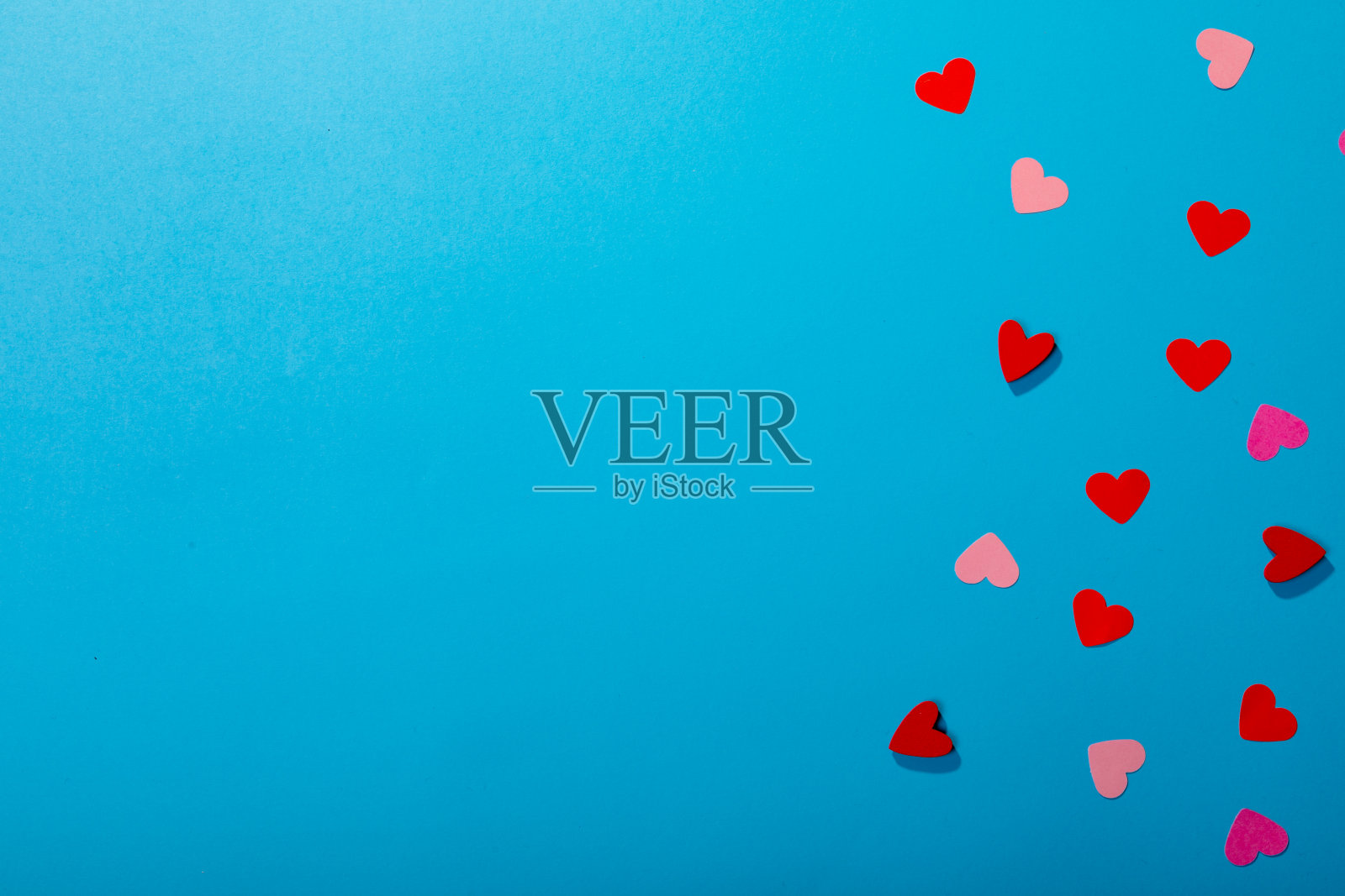 俯视图的红色和粉红色的心孤立在蓝色背景，复制空间照片摄影图片