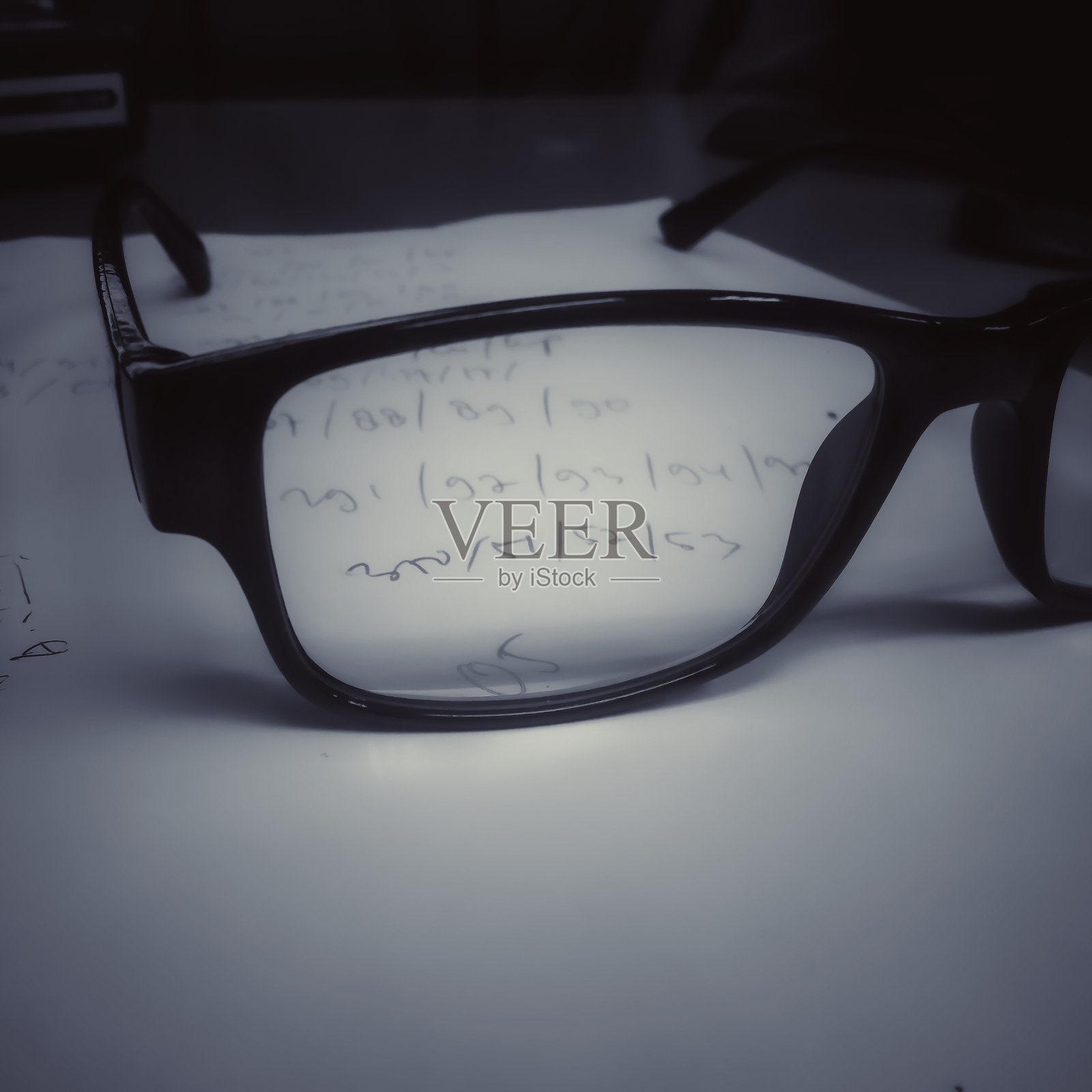 眼镜架在写有数字的纸上照片摄影图片