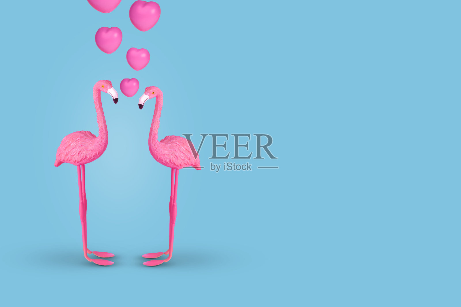 创意有趣的概念与一对火烈鸟在爱在柔和的蓝色背景。插画图片素材