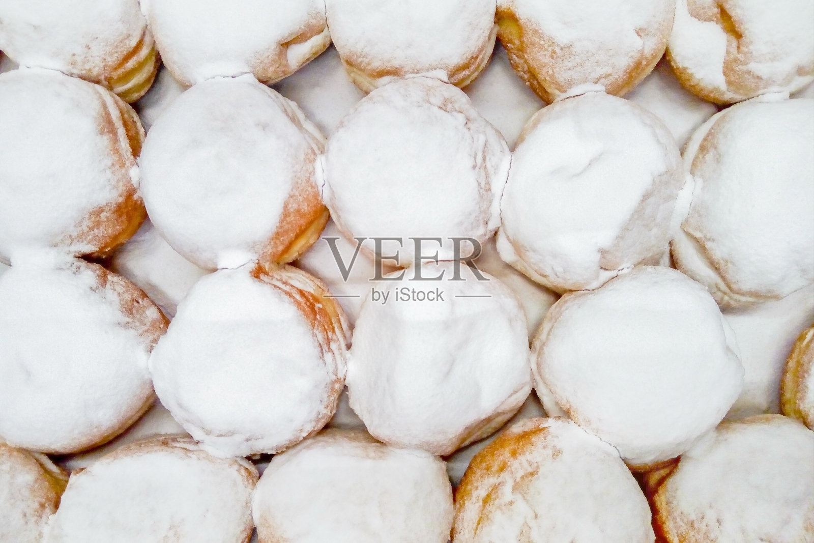 以糖粉为背景的甜甜圈俯视图，质地照片摄影图片