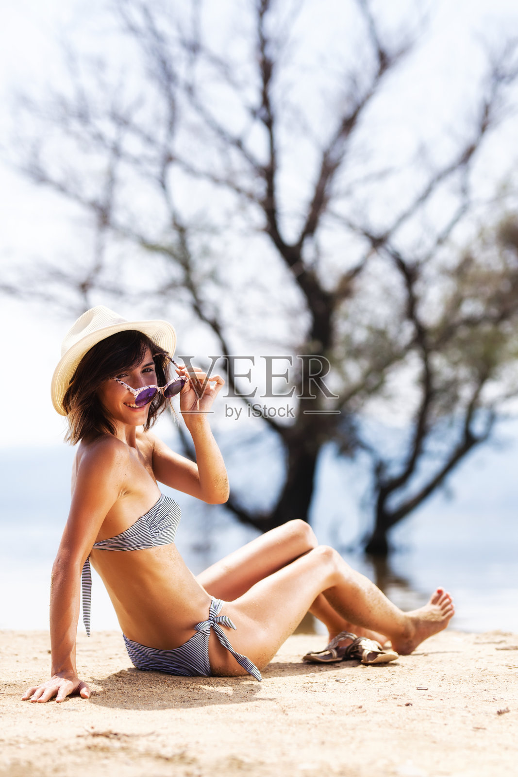 女孩在沙滩上晒太阳照片摄影图片