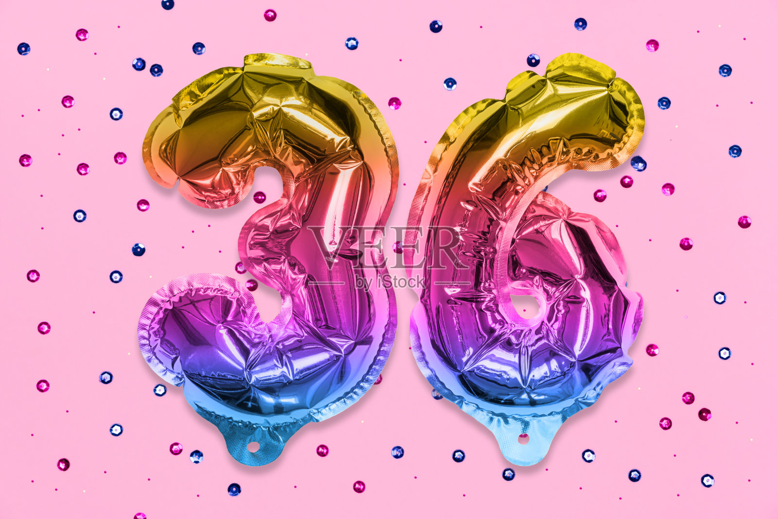 彩虹铝箔气球号码，数字36在粉红色的背景与亮片。生日贺卡照片摄影图片