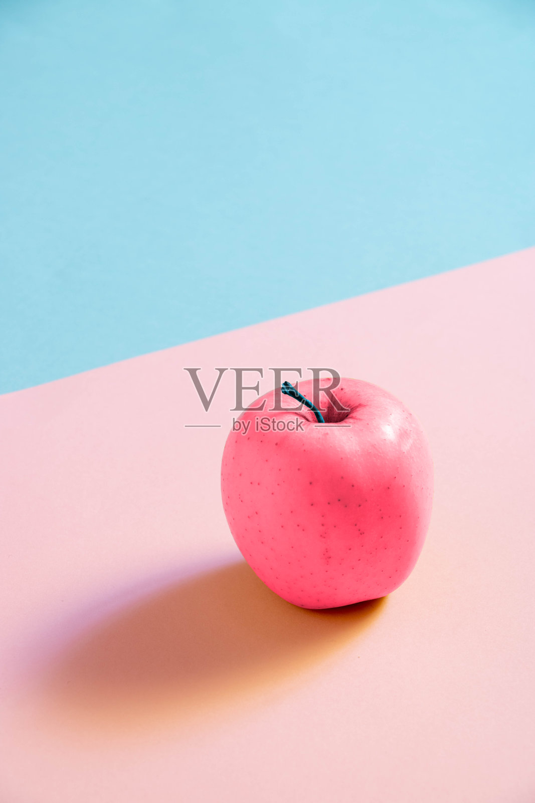 粉红色的苹果在粉红色和蓝色的背景上照片摄影图片
