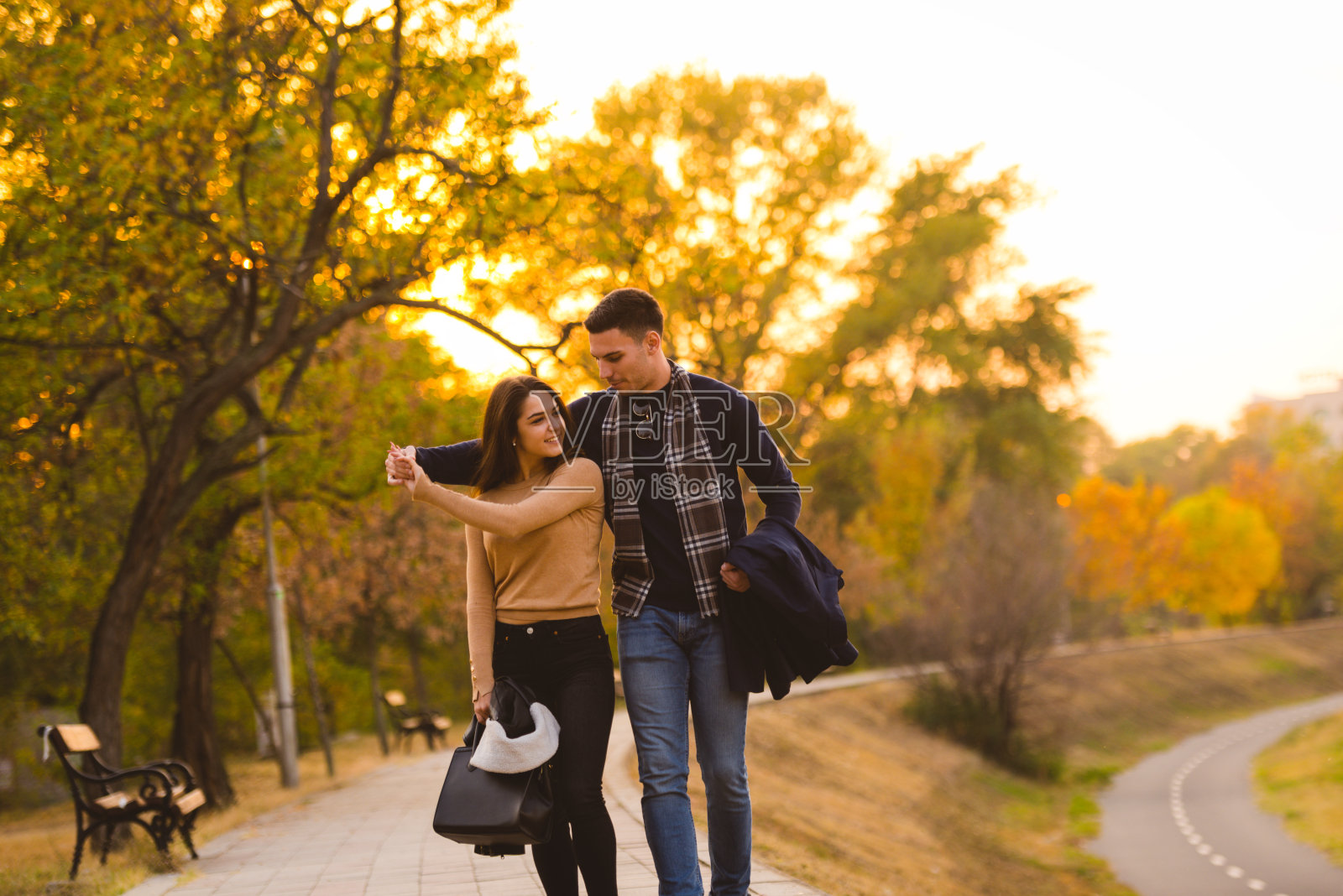 一对情侣在日落前在公园里跳舞。照片摄影图片