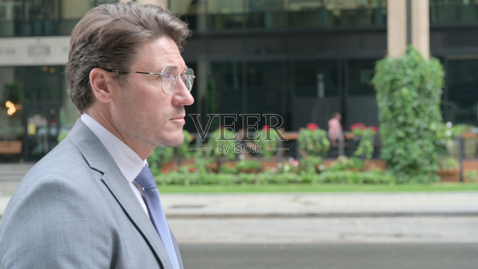 中年商人走在街上的特写，侧视图照片摄影图片