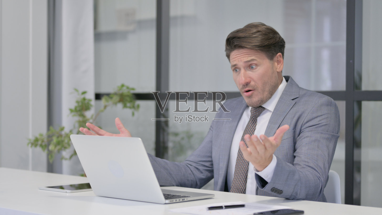 中年男子在办公室使用笔记本电脑时的反应照片摄影图片