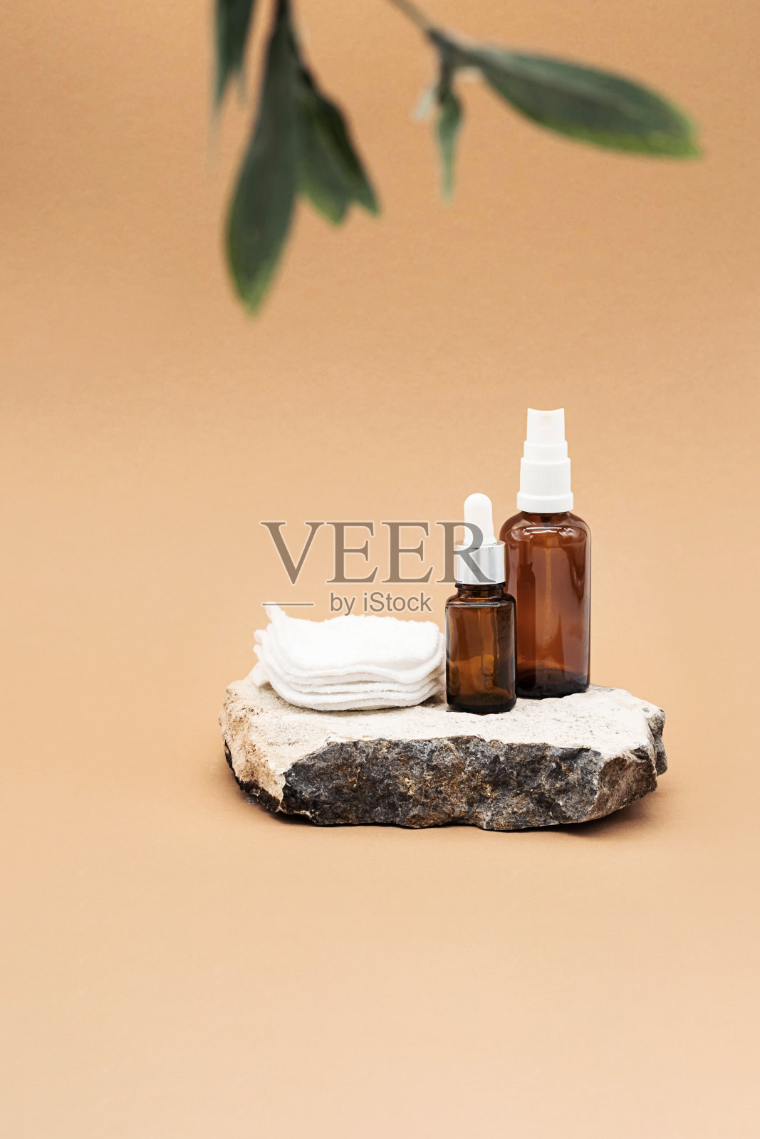 空白琥珀玻璃精油瓶，带吸液管，玻璃喷雾器和可重复使用的海绵放在天然石材平台上。有机水疗美容产品模拟。照片摄影图片