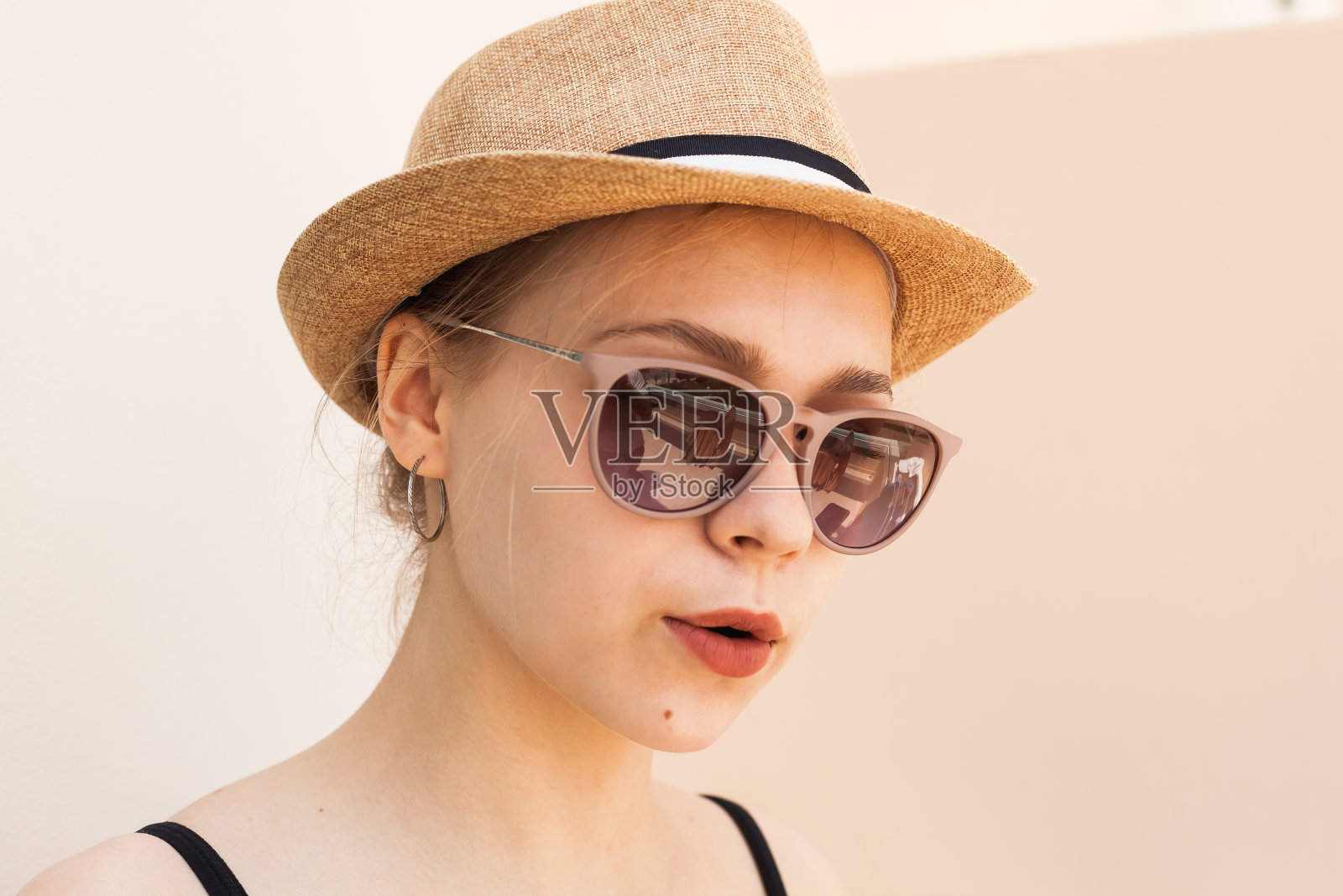 美丽的金发白种人女孩在一个草帽和太阳镜照片摄影图片