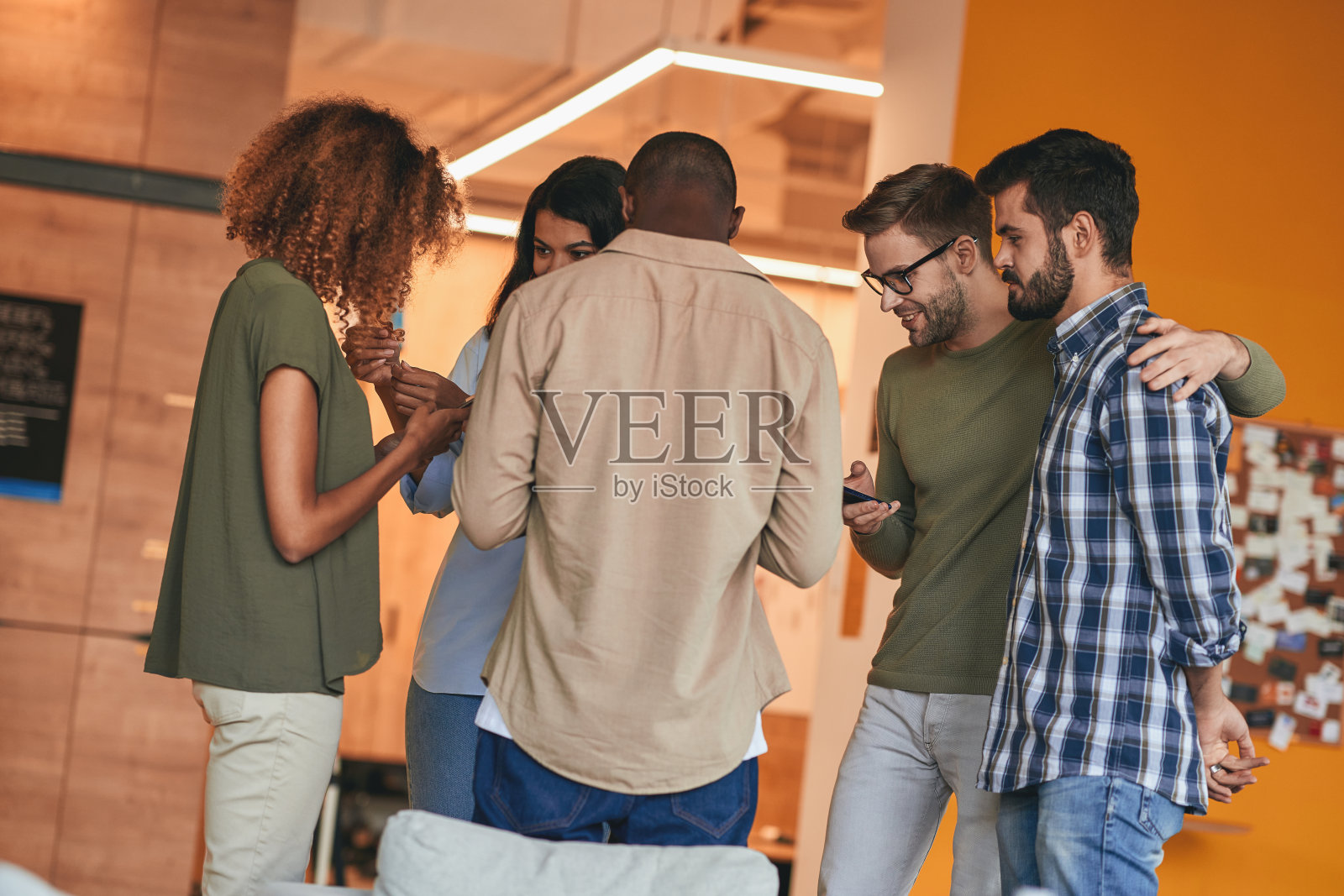 一群成年朋友站在一起玩手机照片摄影图片