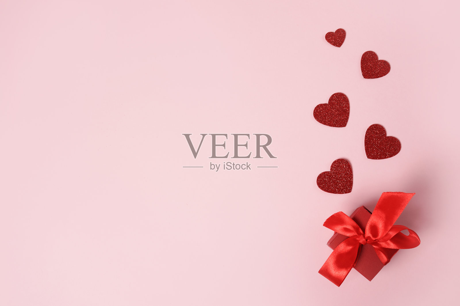 粉色情人节背景上带有红色心形的礼品盒，周年纪念、母亲节和生日祝福，留有文字空间照片摄影图片