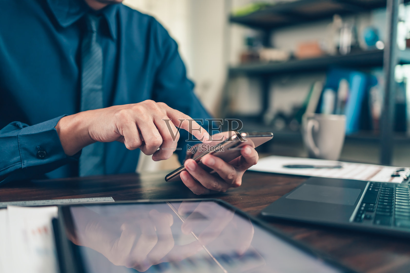 商务人士使用手机，在办公桌上工作，分析会计财务新项目。投资，财务顾问和会计概念。照片摄影图片