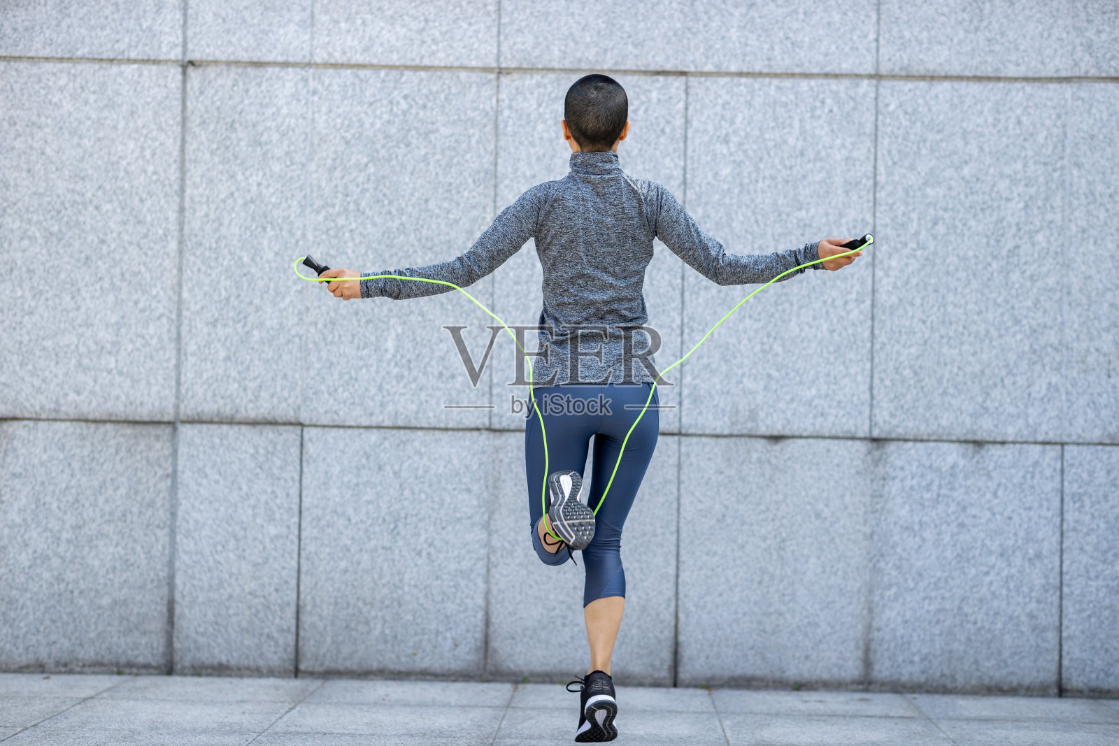 健身女子在城墙上跳绳照片摄影图片