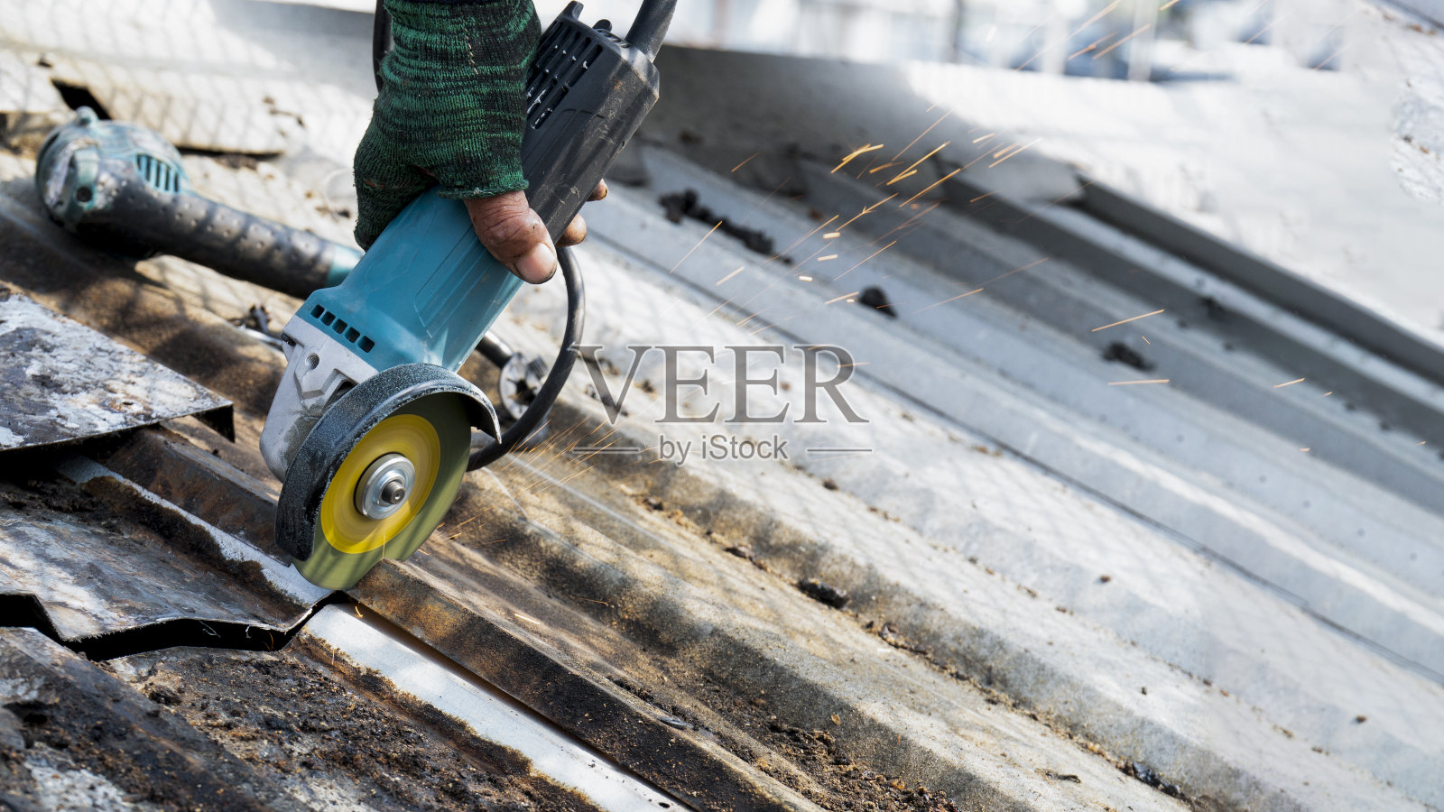 工人们正在使用磨石，切割和固定钢屋顶。照片摄影图片