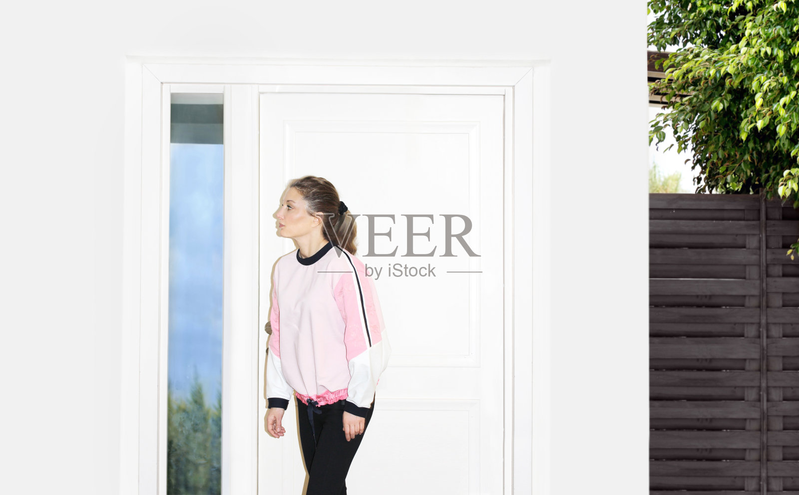 美丽的女人打开了她的家门照片摄影图片