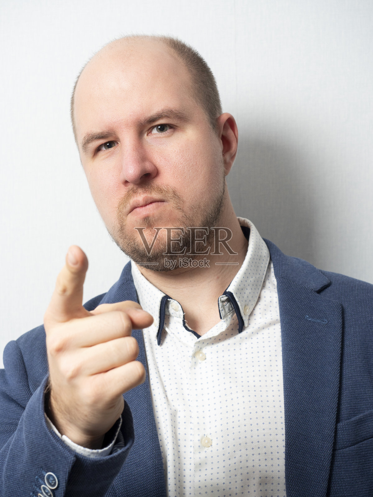 穿着夹克的中年男子用手指着前方的镜头。照片摄影图片