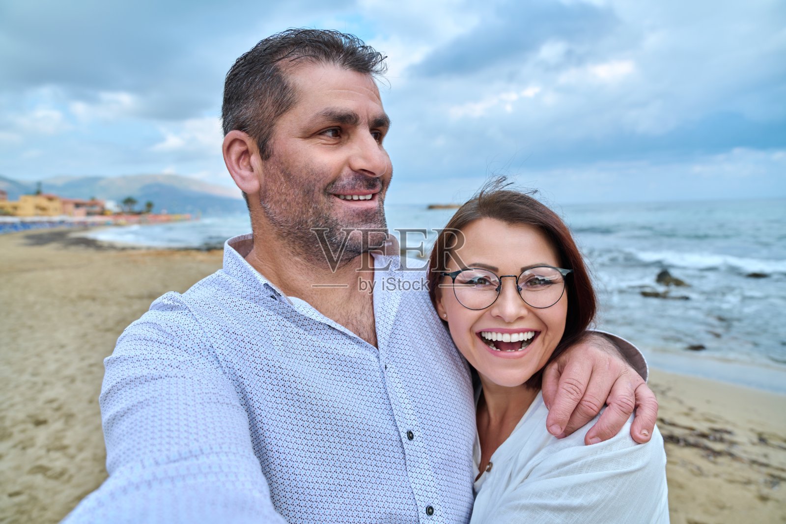 幸福成熟的情侣在用智能手机自拍。照片摄影图片