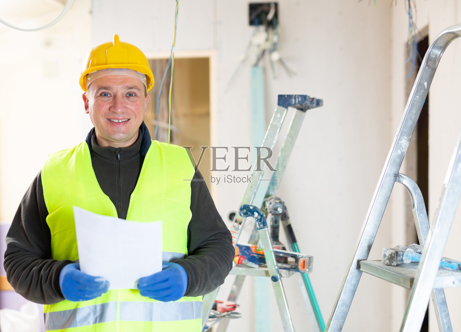 修理工拿着文件站在公寓里照片摄影图片