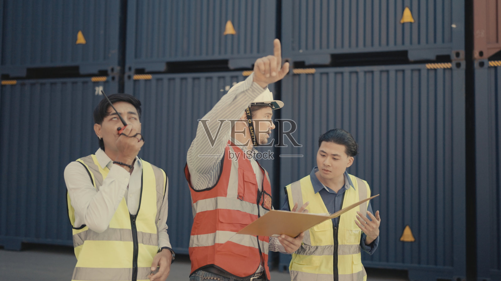 多民族工业组织检查在港口工作的集装箱。照片摄影图片