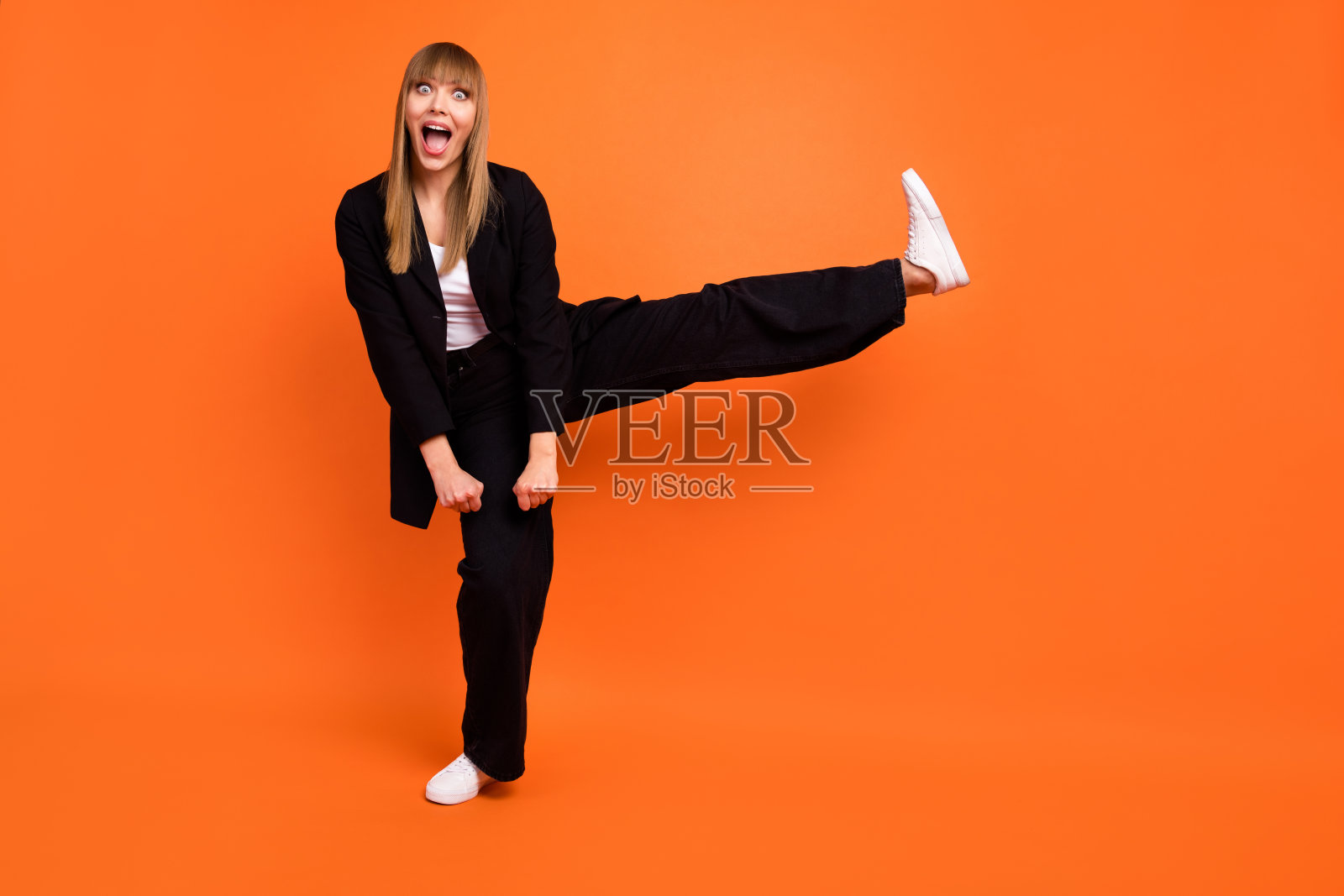 全尺寸照片快乐，兴奋，惊讶，时髦微笑的女孩穿着正装在橙色的背景上嬉戏照片摄影图片