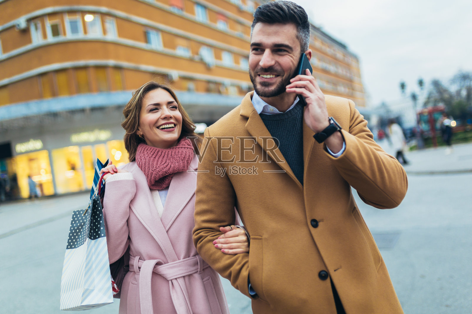 微笑的情侣购物后散步。照片摄影图片