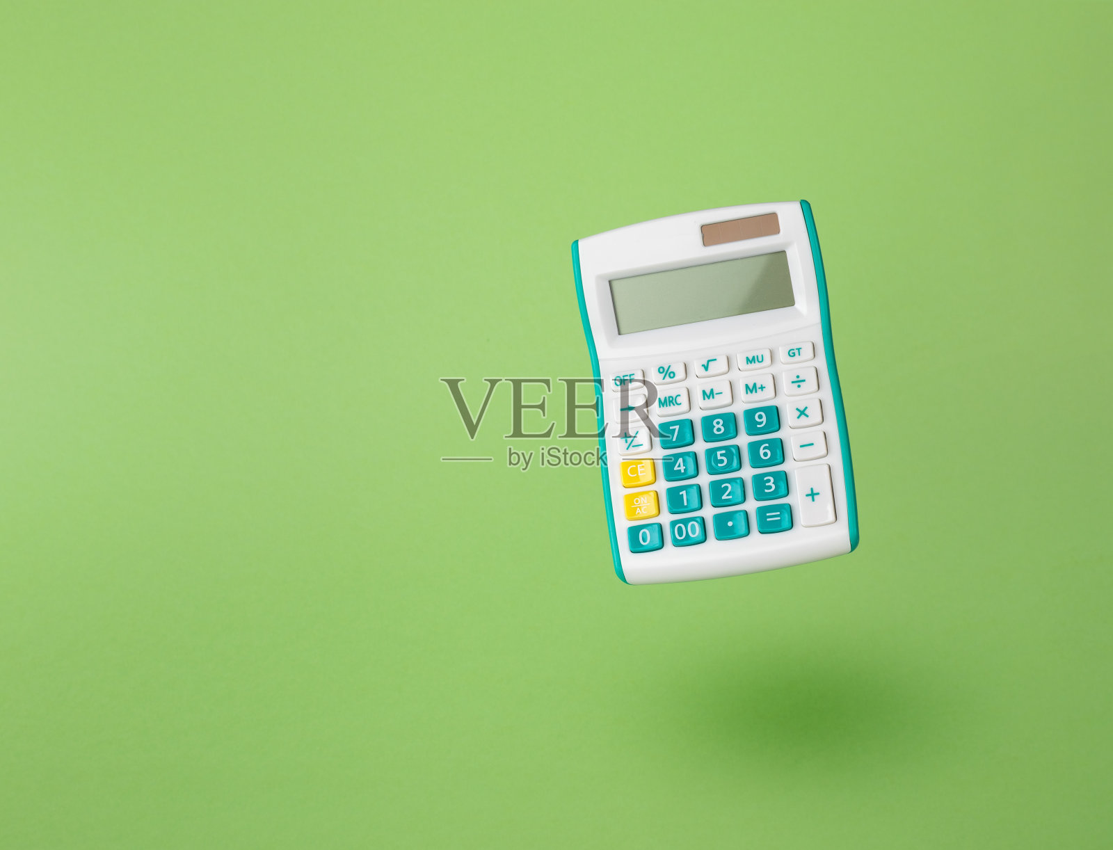 浅绿色背景上的经典计算器。照片摄影图片