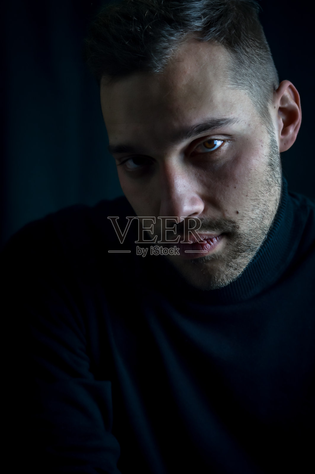 一个年轻男子的肖像在黑色高领与紧张和迷人的外观照片摄影图片