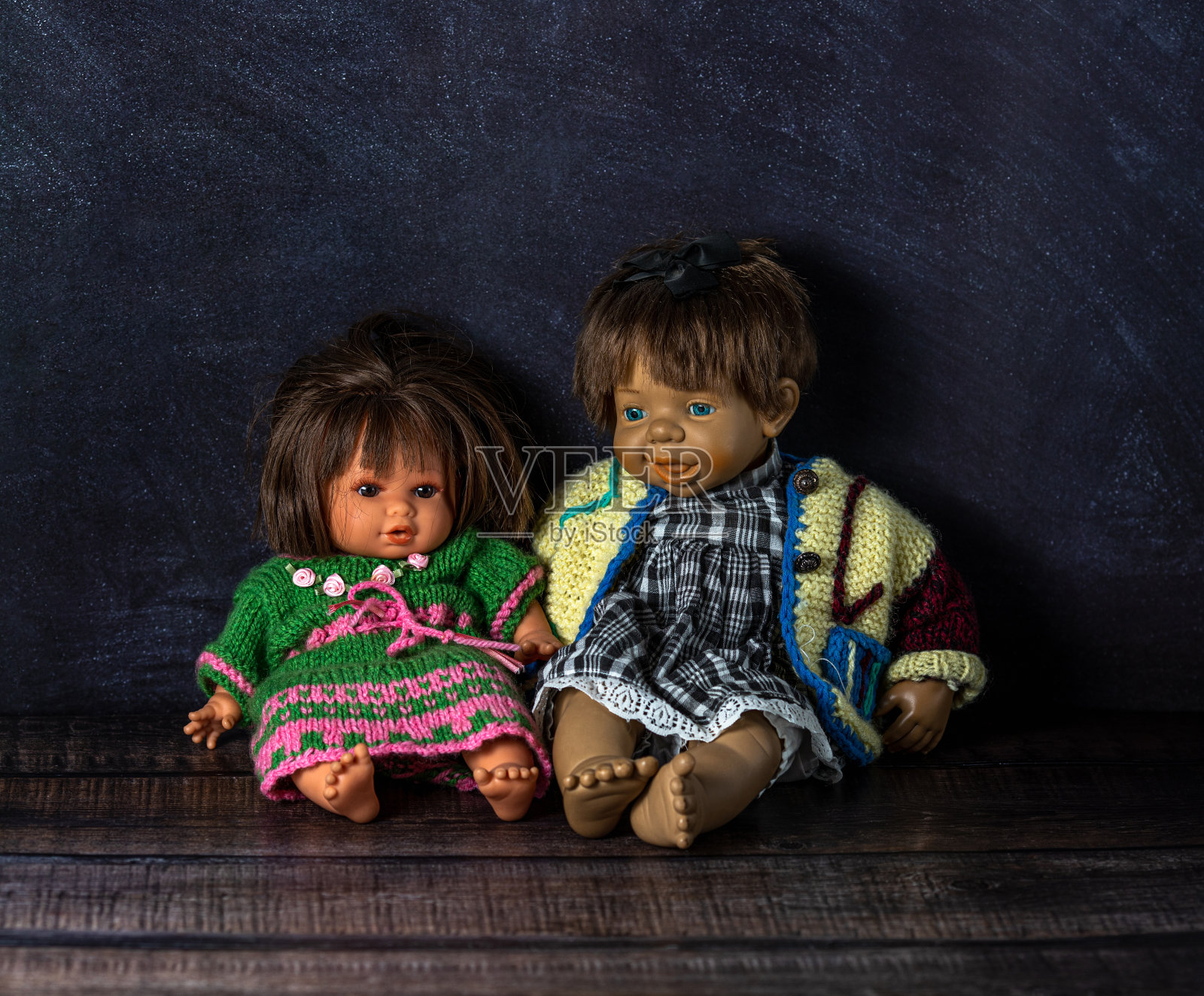 老式树脂娃娃在黑暗的背景。时间的概念。股票的照片。优雅的针织服装。照片摄影图片