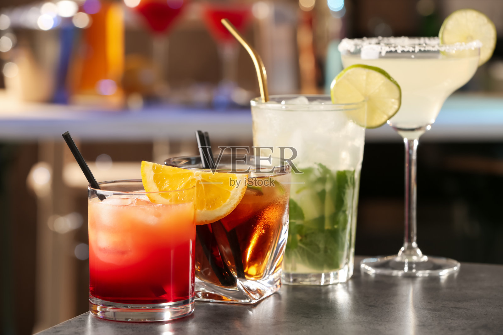 不同的美味鸡尾酒在灰色的桌子在酒吧照片摄影图片