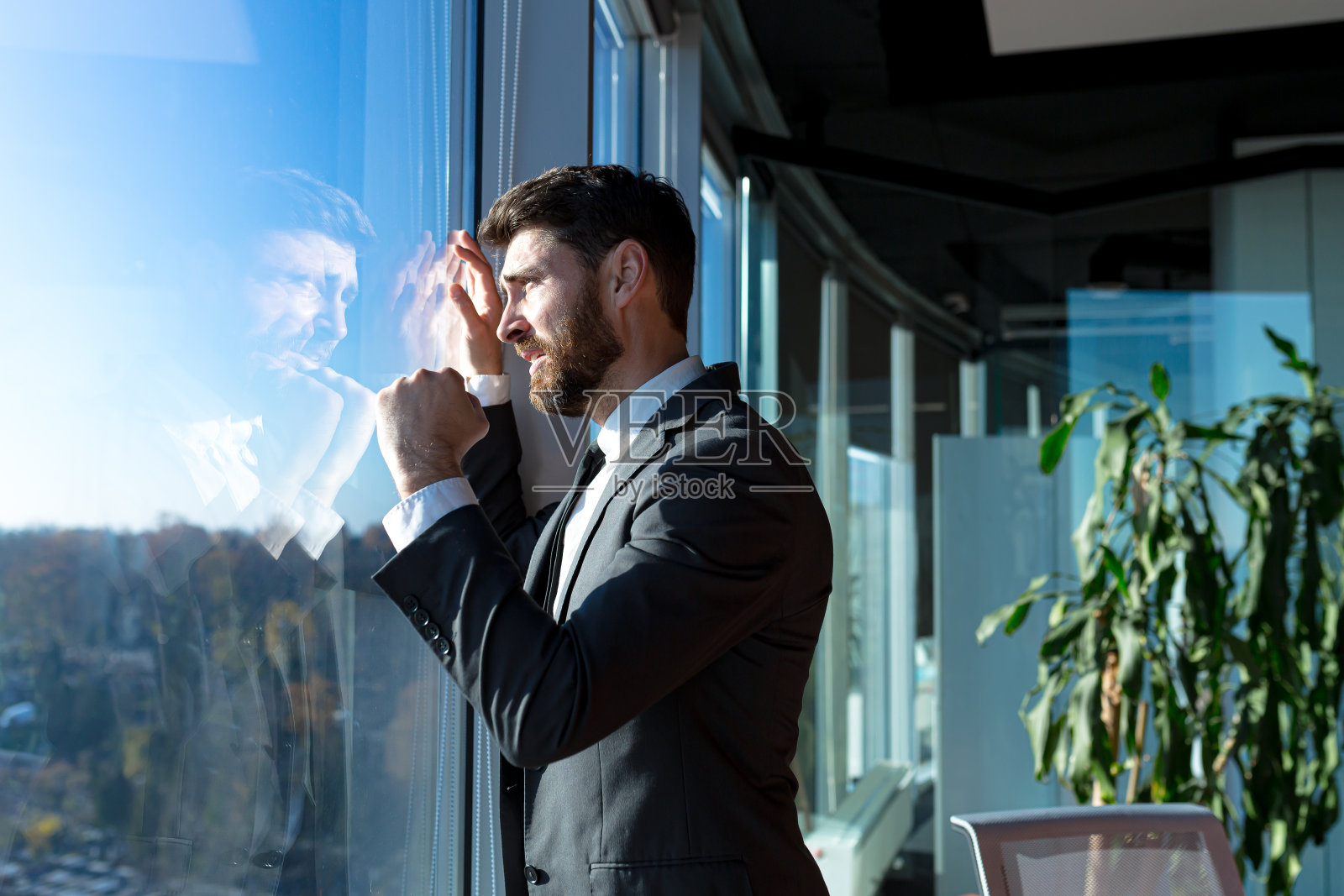 破产的企业家老板沮丧地望着窗外，身穿商务西装，在现代办公室里感到沮丧照片摄影图片