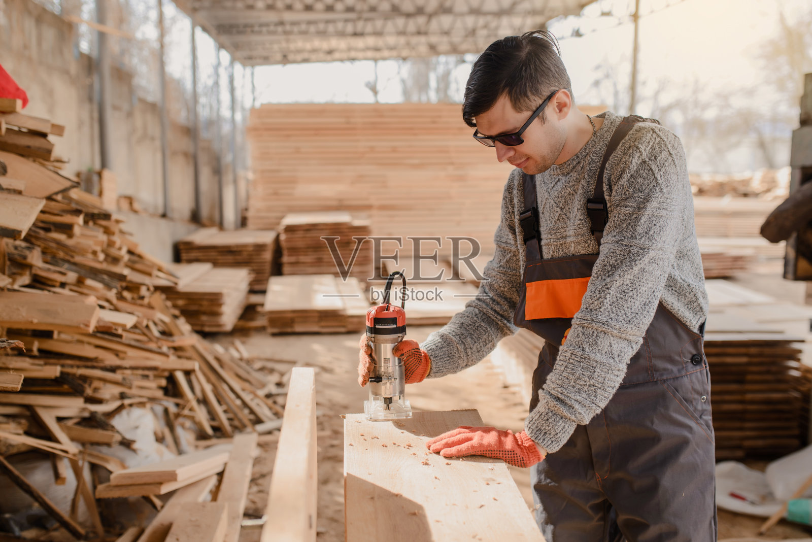 年轻的木匠在木材厂工作照片摄影图片