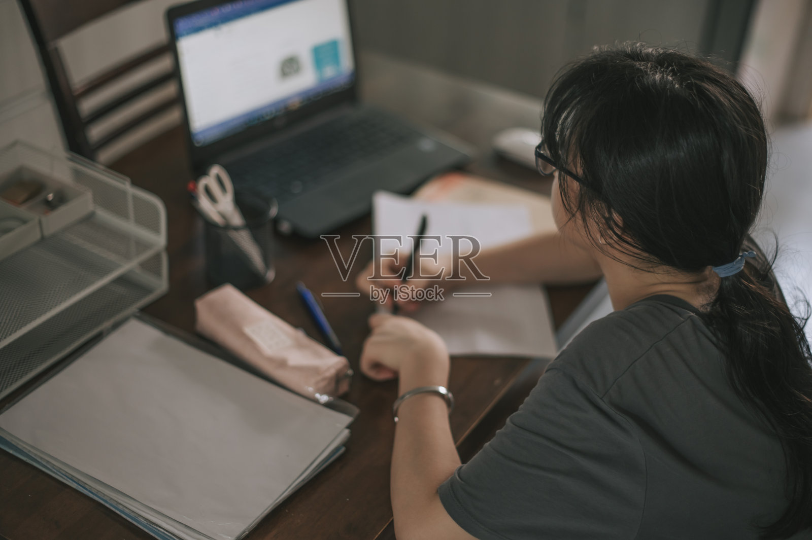 亚洲中国十几岁的女孩在家里厨房的笔记本电脑前做作业学习照片摄影图片