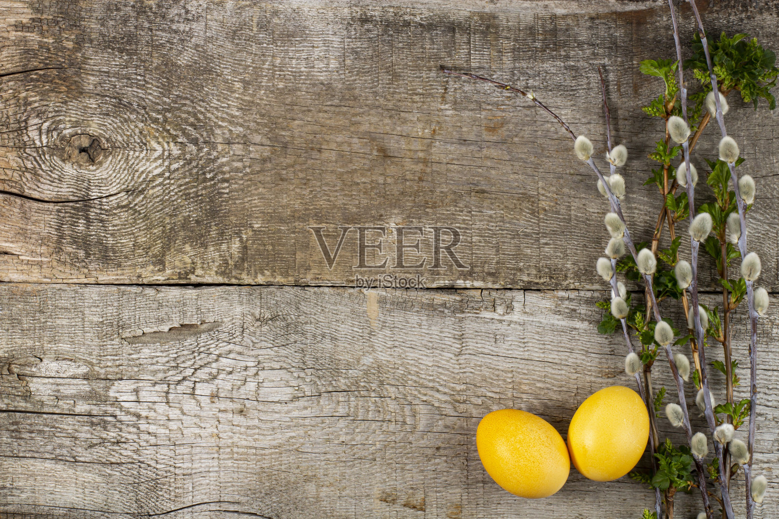 复活节的组成在一个乡村背景，黄色的鸡蛋和年轻的春天树枝与绿色，俯视图，平躺和复制空间。照片摄影图片