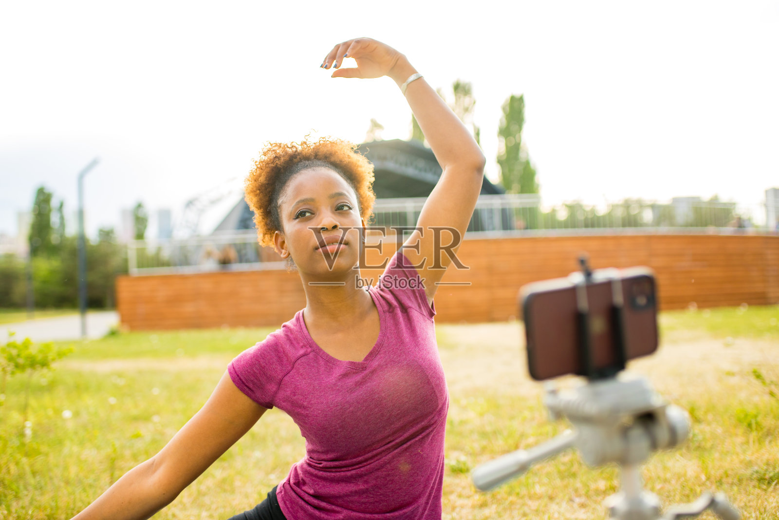 快乐的墨西哥女体育博主用三脚架上的相机记录户外健身训练照片摄影图片