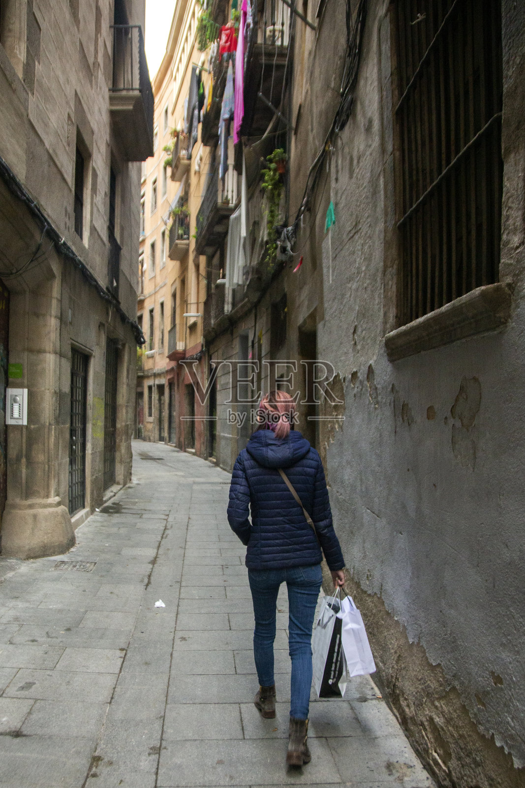 一个女人走在巴塞罗那的街道上照片摄影图片