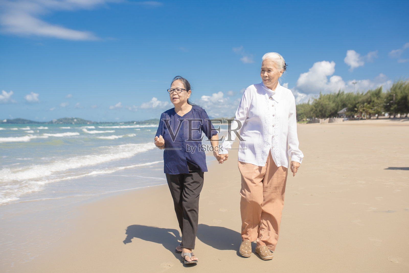 快乐的资深亚洲女性朋友在海滩的肖像。年长的女性朋友在海滩上放松。家庭旅游度假理念照片摄影图片