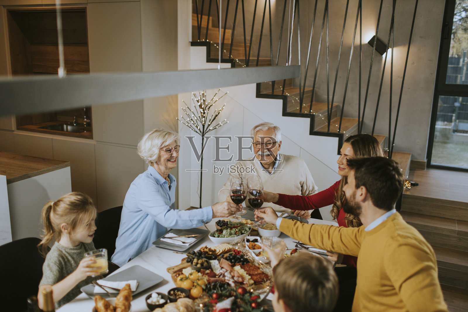 幸福的一家人在家里吃晚餐，喝红酒照片摄影图片