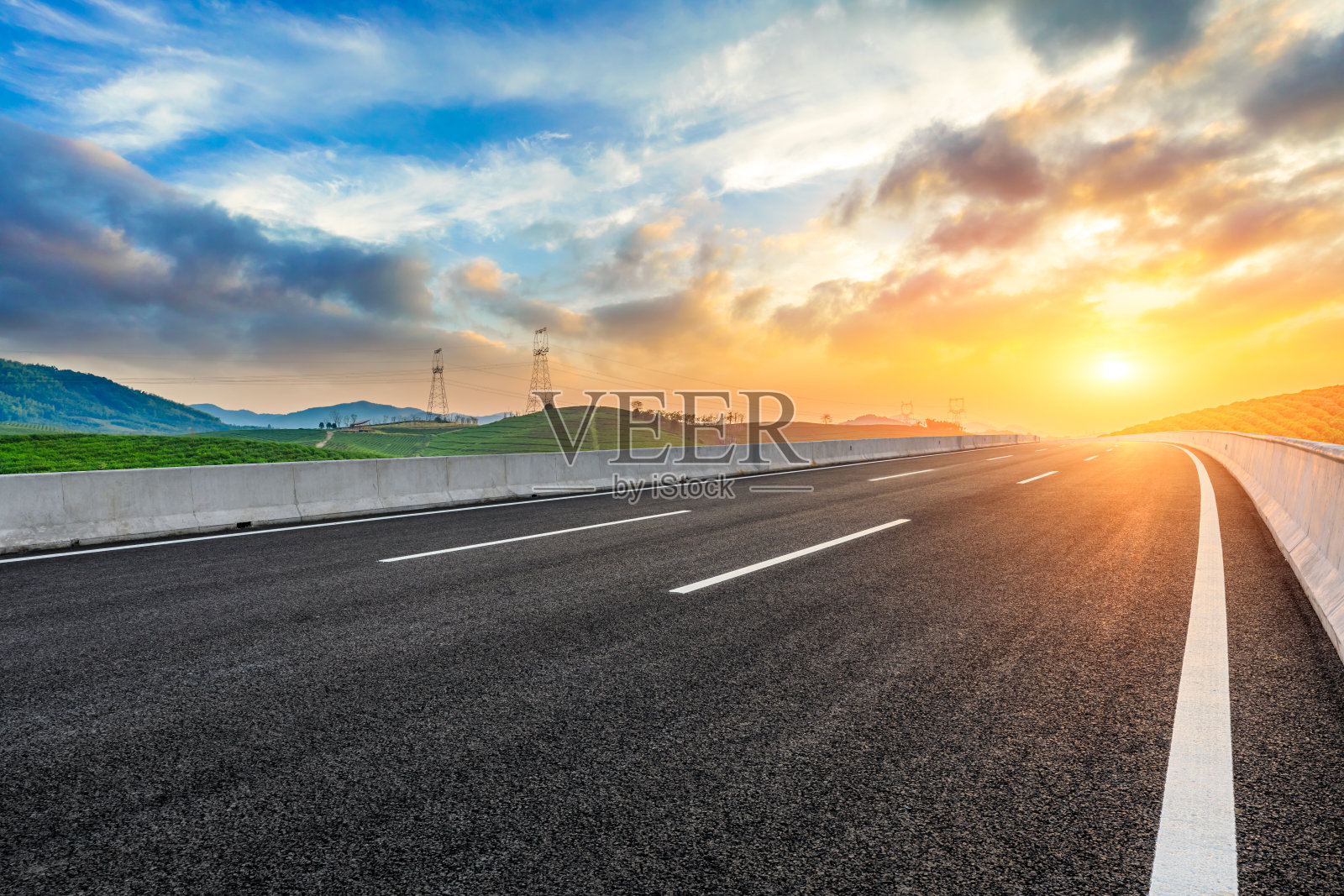 空荡荡的柏油路和夕阳下的山峦照片摄影图片