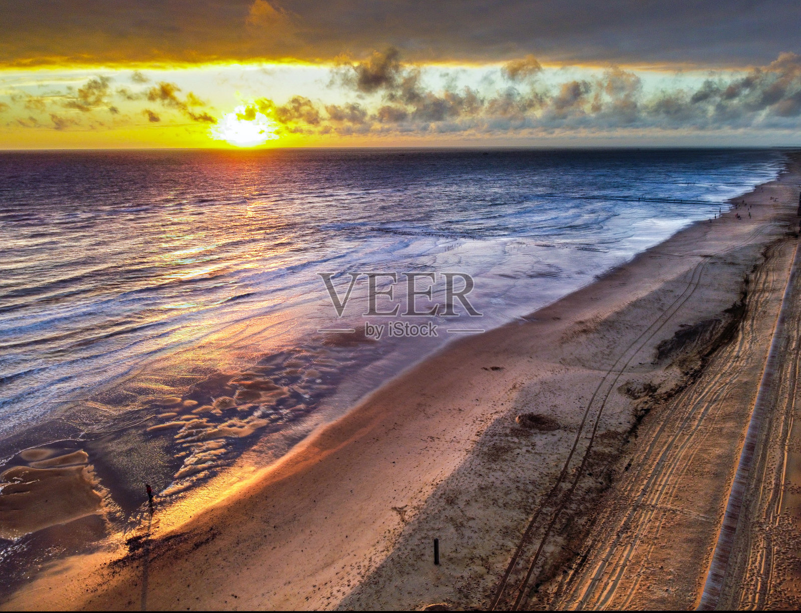 伴着海浪的海滩日落照片摄影图片