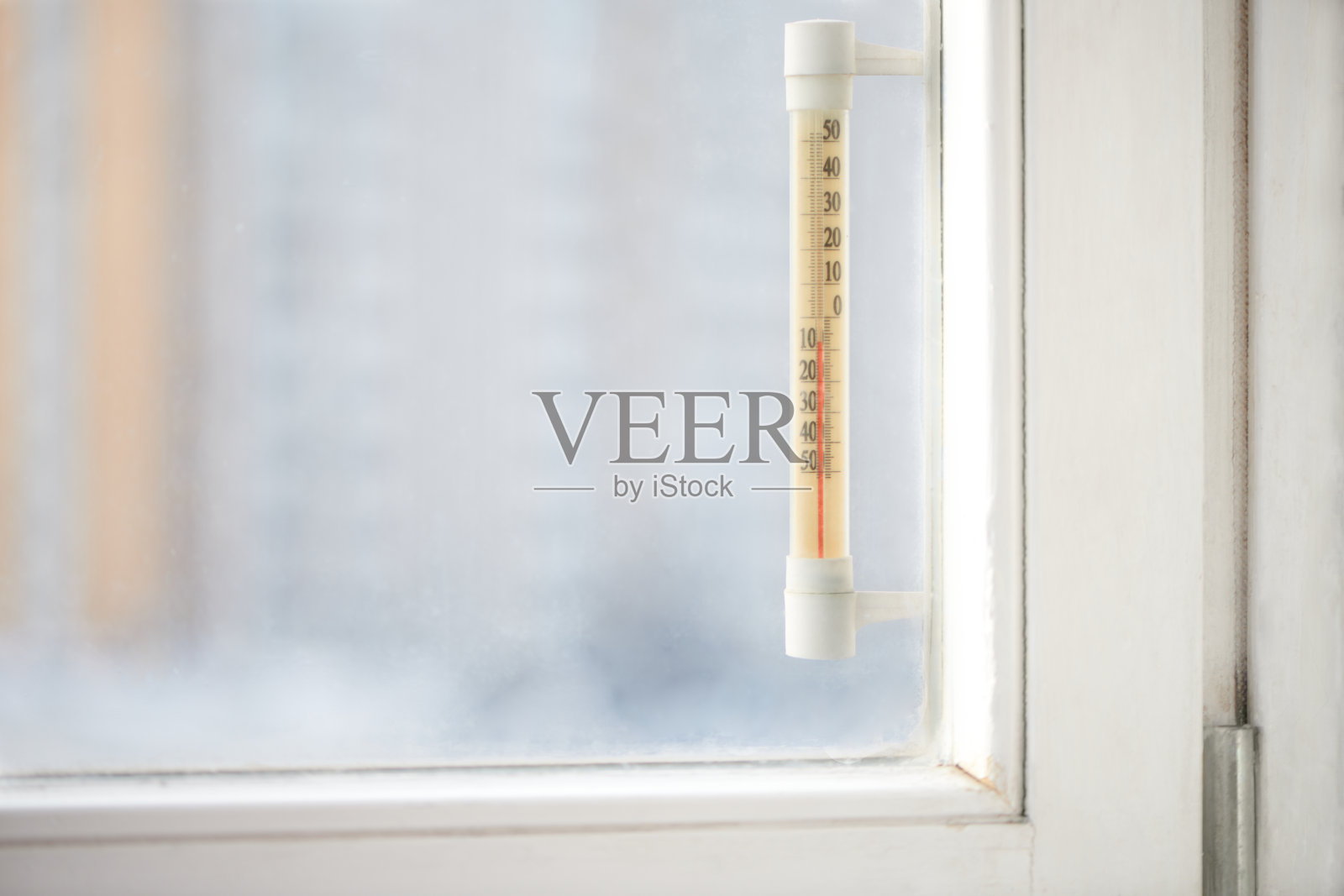 老式室外温度计显示的是负温度。窗户后面有温度计。外面阳光明媚，天气寒冷。照片摄影图片