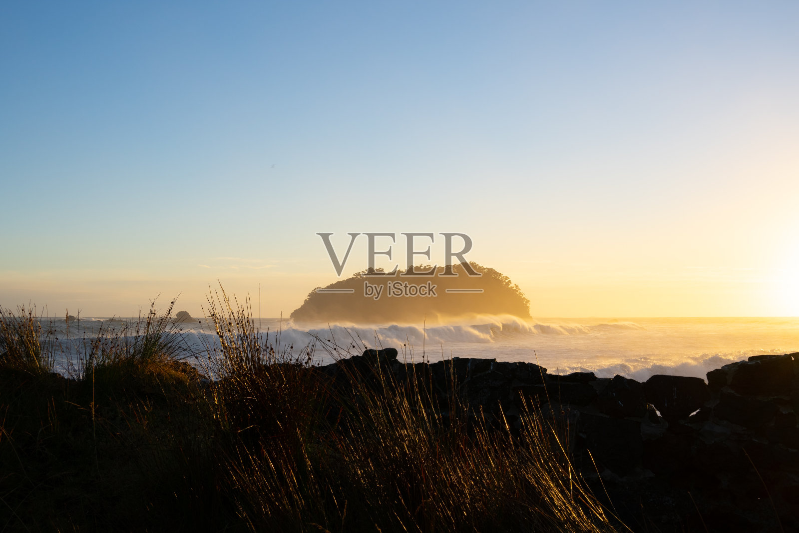 在金色日出的背光下，小岛的剪影照片摄影图片