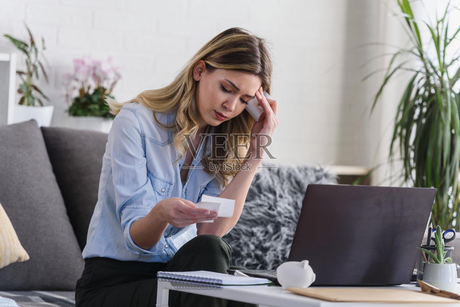 年轻漂亮的女人在家里用电脑工作，计算每月的开销，做家庭预算照片摄影图片